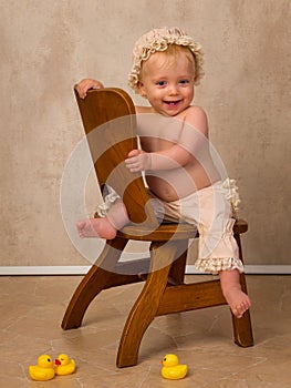 Blonde baby sitting on vintage chair