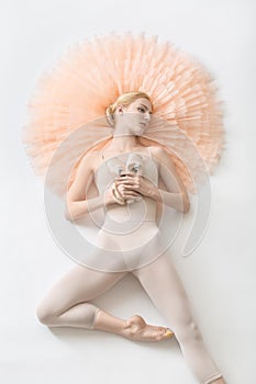 Blonde ballerina lies in studio