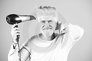 Blonde bearded man hair dry. Handsome man with long hair dries his hair with a hairdryer.