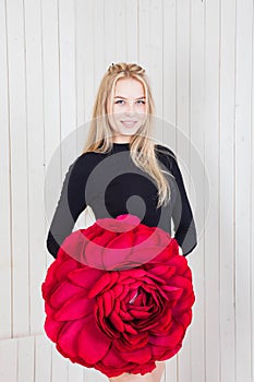 Blonde beauty in a black bodysuit poses with a large red flower