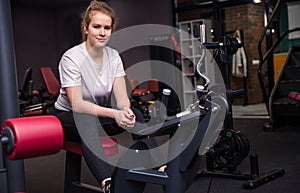 Blonde bodybuilder woman is sitting  in the gym on the bench