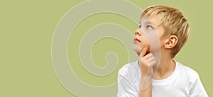 Blonde boy . Let me think . Thoughtful clever schooler in white shirt with puzzled serious expression , child