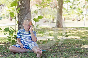 A blonde boy talking on his mobile phone