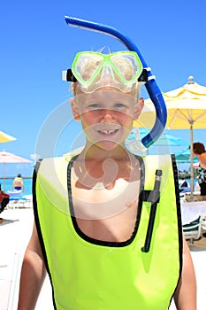 Blonde boy wearing snorkel gear at the beach