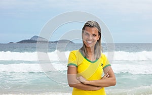 Blonde brazilian sports fan with crossed arms at beach
