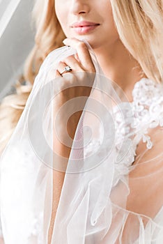 Blonde bride holding transparent cloth