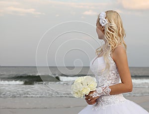 Rubio novia sobre el Playa. mujer hermosa en boda ropa buscando sobre el Océano 