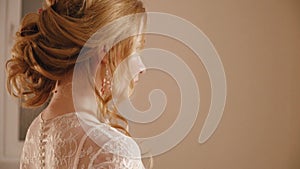 The blonde bride in a wedding dress with flowers posing for the camera