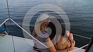 Blonde and brunette lesbian girls relaxing at sailboat trip on river