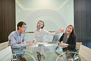 Blonde business man slapping Asian employee in meeting room
