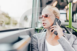 Blonde business woman traveling by bus.