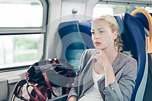 Blonde business woman traveling by train.