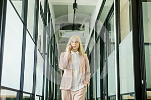 Blonde businesswoman makes a call phone in office