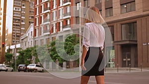 Blonde businesswoman walks in town