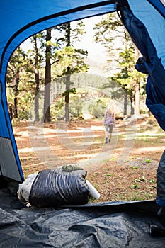 Blonde camper walking away from tent