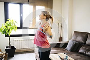 Blonde caucasian athlete woman doing exercises with elastic band in living room at home