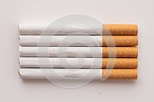 blonde cigarettes with filter on a white table, white background