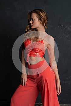 Blonde in coral bustier and slacks