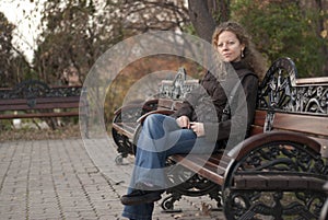 Blonde curly girl relaxing in a park