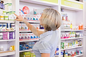 Blonde customer pointing medicine from shelf