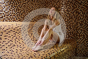 A blonde cute young woman in a hammam looking relaxed