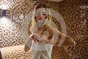 A blonde cute young woman in a hammam looking relaxed