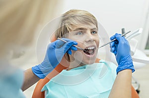 Blonde Dentist Examines the Boy`s Teeth