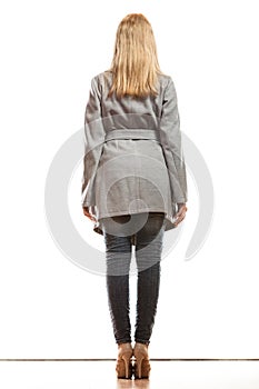 Blonde elegant woman in gray coat rear view