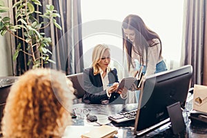 Blonde executive businesswoman doing multitasking work in office.