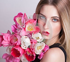 Blonde face,  blue eyes, tulips flowers