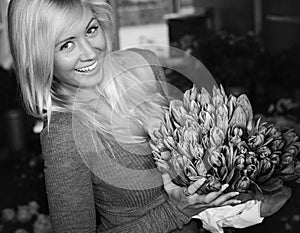 Blonde female holding tulips