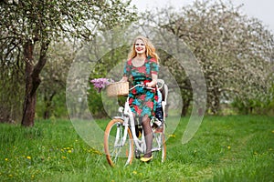 Blonde female riding city bicycle with baby in bicycle chair