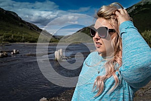 Blonde female stands near the Savage River in Denali National Pa