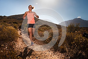 Blonde female trail runner running through a mountain landscape