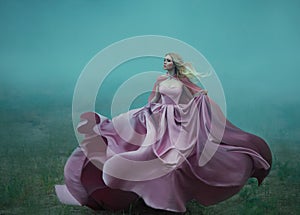 Blonde in the fog in a light long expensive royal dress fluttering on the fly, takes the form of a magic flower, a