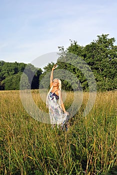 Blonde girl alone in field.