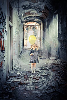 Blonde girl with a balloon inside a decadent and abandoned building
