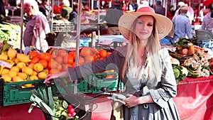 Blonde girl with bike standing at the market, smiling