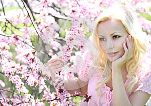 Blonde Girl with Cherry Blossom. Spring Portrait. Beautiful