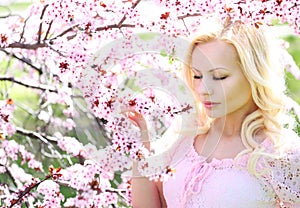 Blonde Girl with Cherry Blossom. Spring Portrait.