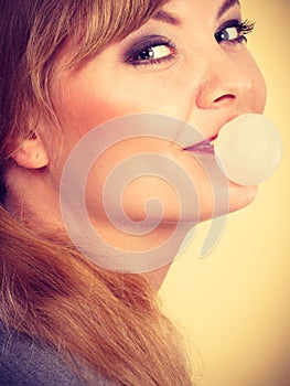 Blonde girl chewing gum making balloon.