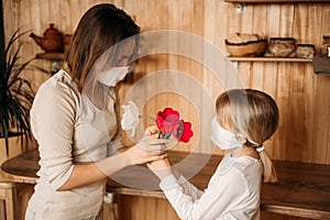 Blonde girl congratulate mom on her mother`s day, gives her tulips. Holiday at home on quarantine