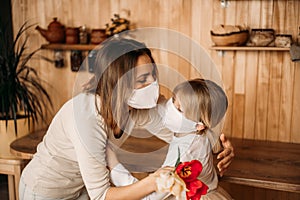 Blonde girl congratulate mom on her mother`s day, gives her tulips. Holiday at home on quarantine