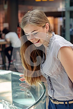 Blonde girl considers jewelry in the store photo
