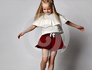 blonde girl dances and whirls on a white background.