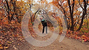 Blonde girl does excercises in the autumn forest