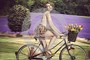 blonde girl going on the bicycle on field