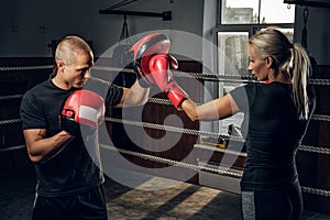 Blonde girl has a training with experienced boxer