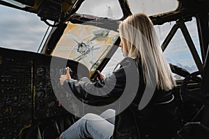 A blonde girl at the helm inside a military decommissioned An-12 cargo plane photo
