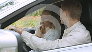 A blonde girl and her boyfriend are arguing, sitting in the car. Irritation and quarrel.